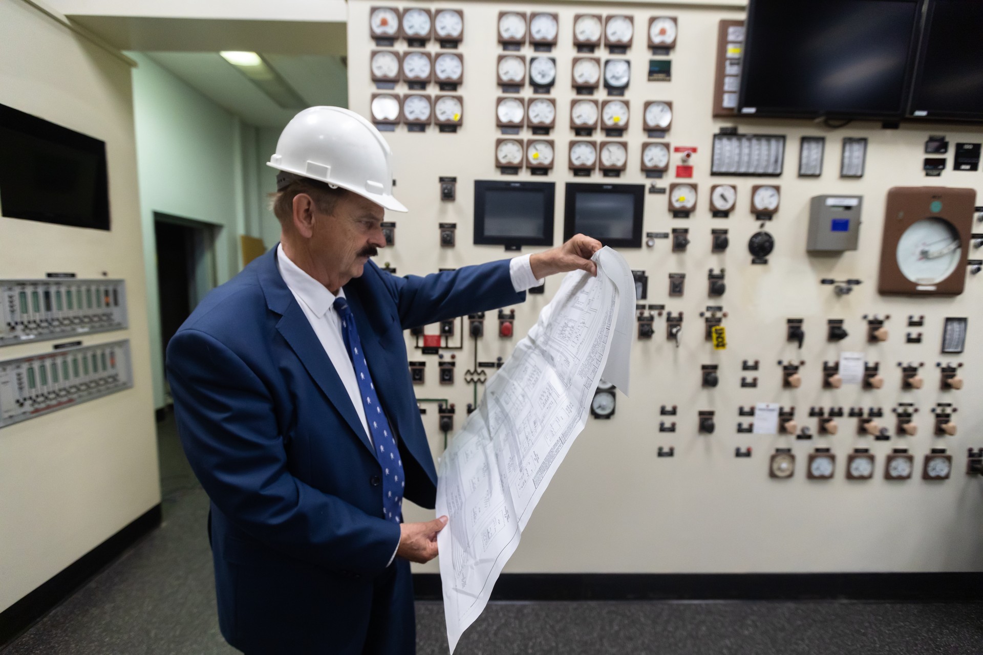 Senior Engineer Reading Diagrams in Power Station Control Room